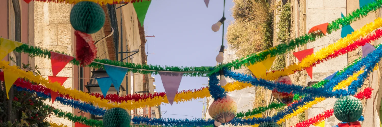 Colourful paper cascatas decorations strung across a Lisbon alley for Santos Populares